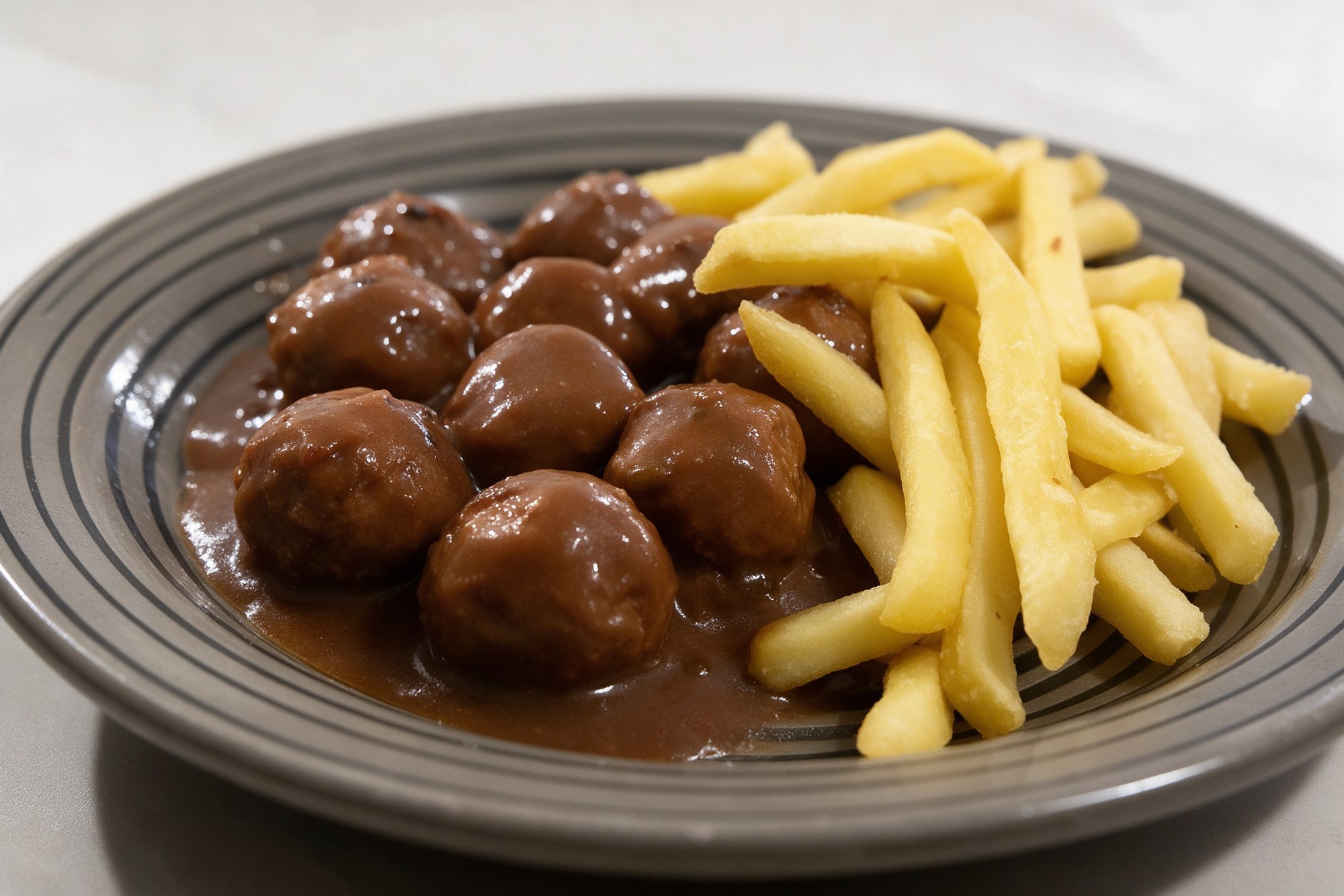Plato de albóndigas caseras en salsa con patatas fritas